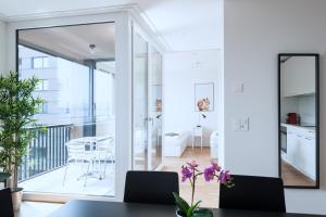巴塞尔HITrental Basel Apartments的一间拥有白色墙壁和大镜子的用餐室