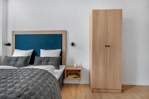 哥本哈根STUDIO1A Hotel Apartments的一间卧室配有一张大床和一个木制橱柜