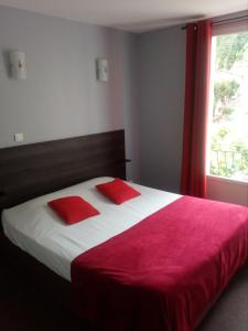 巴纳斯巴纳客栈的一间卧室配有一张带红色枕头的床和一扇窗户