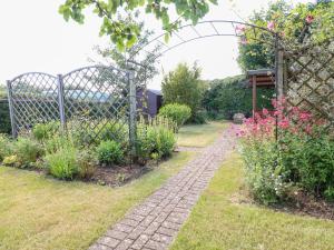 切尔滕纳姆Well Cottage的一个带栅栏和砖道的花园