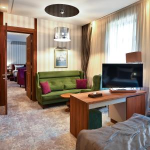 萨拉热窝Heritage Hotel Krone的客厅配有绿色沙发和电视