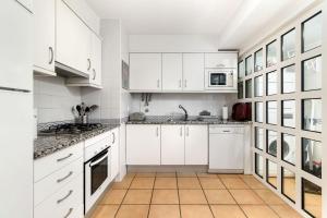 奎特里拉Vila Sol Resort 2 Bedroom Family Apartment的厨房配有白色橱柜和瓷砖地板。