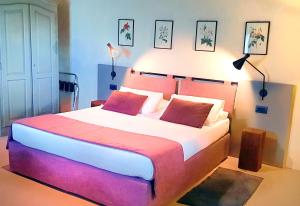 圣吉米纳诺Il Palagione的一间卧室配有一张大床和两个红色枕头