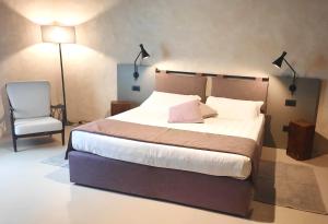 圣吉米纳诺Il Palagione的一间卧室配有一张大床和一把椅子