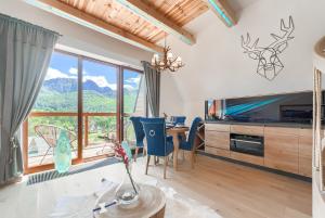 考斯赛力克Tatra Resort & SPA的客厅设有桌子和大窗户