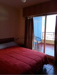 塞代拉Apartamento Piscina Playa Cedeira的卧室配有红色的床和滑动玻璃门