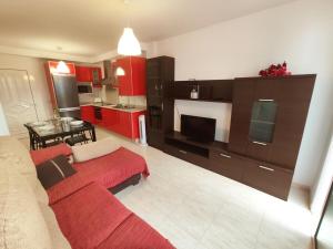 宏达海滩Ámbar的一间带红色沙发的客厅和一间厨房