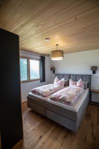 梅劳Panoramahof Bergglück的卧室配有一张带粉红色枕头的大床