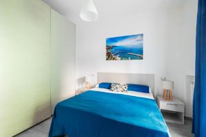 索伦托Dreamers' House Sorrento的一间卧室配有蓝色的床和蓝色的毯子