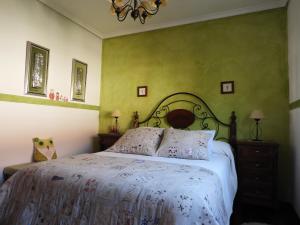 HelgueraTranquilidad en helguera的一间卧室配有一张带白色床单和绿色墙壁的床。