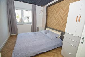派尔努Casa Monkey Pärnu with sauna and terrace的一间卧室设有一张床和一个大窗户