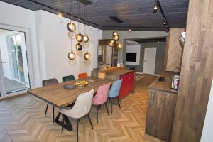 派尔努Casa Monkey Pärnu with sauna and terrace的厨房以及带木桌和椅子的用餐室。