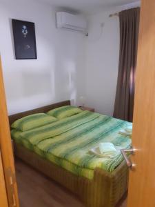 索科矿泉村Apartmani Janosevic的一间卧室配有一张带绿色棉被的床