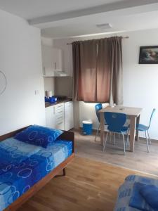 索科矿泉村Apartmani Janosevic的卧室配有一张床和一张桌子及椅子