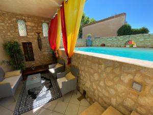 圣洛朗代阿尔布雷圣劳伦酒店的一个带游泳池的庭院和一个带遮阳伞的墙壁
