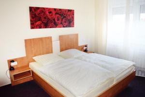威斯巴登Hotel Meuser的卧室内的一张床铺,墙上有红色的画作
