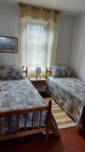 圣维森德马尔Estupendo apartamento en San Vicente do Mar O Grove的一间卧室设有两张床和窗户。