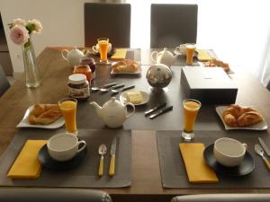 VernouilletChambres d'hôtes dans maison contemporaine的一张桌子,早餐包括羊角面包和橙汁