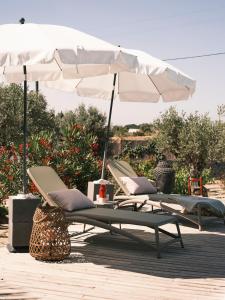 塞图巴尔Rêves Étoilés的庭院设有两把躺椅和一把遮阳伞