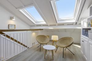圣让-德吕兹Superb 3 stars flat w balcony - Saint-Jean-de-Luz - Welkeys的客房设有天窗、两把椅子和一张桌子