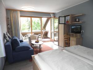 比绍夫斯格林伽斯特豪斯索纳克酒店的一间卧室设有一张床,客厅设有电视。
