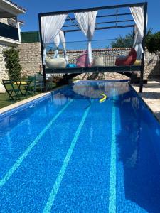 阿拉恰特Grand Alaçatı Butik Hotel的一个带桌椅的大型蓝色游泳池