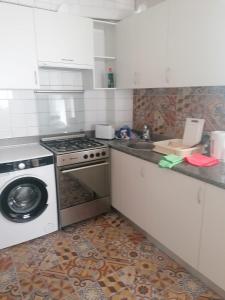 瓦伦西亚Malvarrosa apartamentos的厨房配有炉灶和洗衣机。