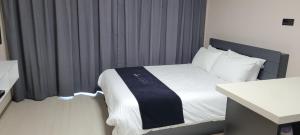 江陵市Gangneung hi ocean gyeongpo a203的一间卧室配有一张带黑白毯子的床