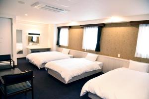 宫崎宫崎第一酒店的客房设有两张床、椅子和窗户。