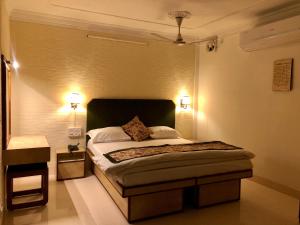 西里古里Hotel Saluja的一间卧室配有一张带两个灯的床