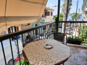 卡拉内拉ΑΡΓΩ的阳台配有桌子和雨伞。