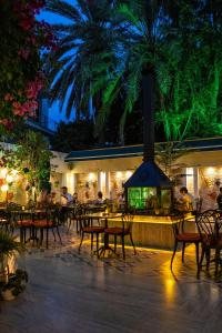 安塔利亚卡莱亦奇路线酒店 - 仅限成人（12岁以上）的一间棕榈树餐厅,配有桌椅