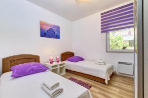 康斯基Casa Verde的配有紫色枕头和窗户的客房内的两张床