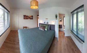布鲁日Ten Hove Brugge的一间卧室设有蓝色的床和2个窗户。