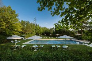 埃尔萨谷口村黎莱斯德拉罗维雷酒店的一个带桌椅和遮阳伞的游泳池