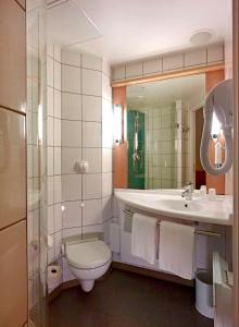 华沙华沙雷杜塔宜必思酒店的一间带卫生间、水槽和镜子的浴室