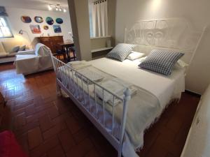 Cisano sul NevaIndependent apartment with a fabulous patio - Casa Penny的卧室配有带蓝色枕头的大型白色床