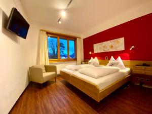 因特拉肯托斯卡纳酒店的红色墙壁的客房内的两张床