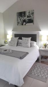 斯泰伦博斯Two Vines Romantic Guest Studio的一间卧室配有一张带两盏灯的大型白色床。