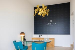 切法卢Abelia Sea Suites的一间带桌子和蓝色椅子的用餐室