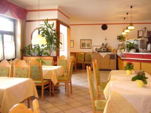 阿皮亚诺苏拉斯特拉达Hotel Gasthof WASTL的一间带桌椅的餐厅和一间厨房