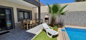 非斯Villa Nour的一个带桌椅的庭院和一个游泳池