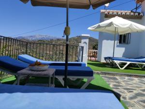 托罗克斯Villa Las Encinas COSTA DEL SOL的庭院配有桌椅和遮阳伞。