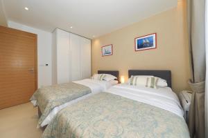 扎达尔Villa Manda Zadar Luxury Apartments的一间酒店客房,房间内设有两张床