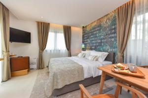 扎达尔Villa Manda Zadar Luxury Apartments的酒店客房配有一张床铺和一张桌子。