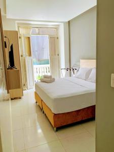 卡塔赫纳Hotel Gallery Cartagena的一间卧室设有一张床和一个窗口