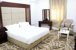 Dawmat al JandalAl Farhan Dumah Al Jandal的一间卧室配有一张大床和一把椅子