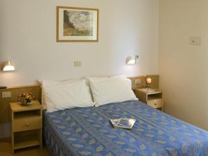 里乔内尼维斯酒店的一间卧室配有一张床,上面有托盘