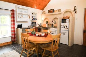 百利科内尔Wisteria Cottage的厨房配有木桌和椅子