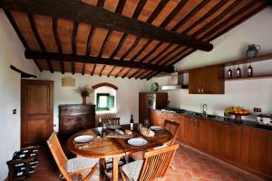 基安蒂格雷夫Villa Rosano的厨房配有带椅子的木桌和桌子。